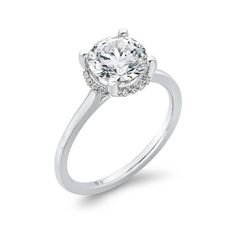 a white gold ring with an oval cut diamond in the center and pave set shoulders