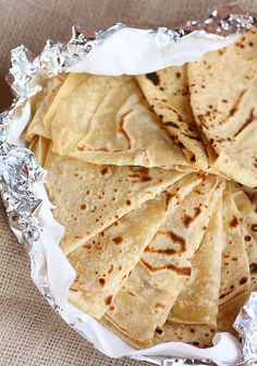 some tortillas are sitting in foil on a table