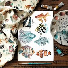 an art project with watercolors and ink on paper, including paintings of fish