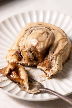 a white plate topped with cinnamon rolls covered in frosting and caramel icing