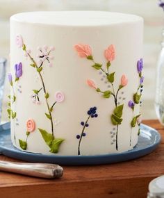 a cake with flowers painted on it sitting on a table