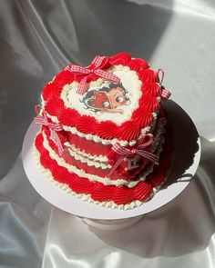 three tiered cake decorated with red and white icing on top of a plate