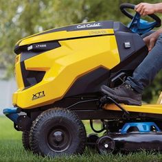 a man riding on the back of a yellow lawn mower