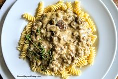 a white plate topped with pasta covered in gravy