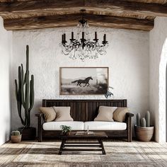 a living room filled with furniture and a chandelier hanging from the ceiling over a wooden coffee table