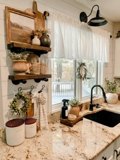 the kitchen is decorated in white and has lots of decorations on the window sill