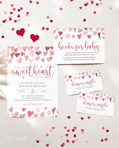 wedding stationery with hearts on it and confetti falling from the ceiling in the background