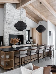 an open kitchen and dining room with stone walls, wood ceilinging and exposed beams