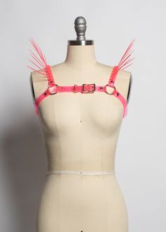 The neon version of the Replicant Chest Harness! Cyberpunk inspired harness made in colorful PVC. Dramatic spikes fan out at the shoulder to create a striking, avant garde, futuristic look. Fit is adjustable with buckle at chest. Silver-toned nickel plated steel hardware. Spikes are plastic zip ties/cable ties and are lightweight and flexible. Available in neon pink (shown) or lime green. Neon pink and neon orange PVC areUV reactive, the lime green PVC is NOT. All spikes colors are UV reactive. Chest Harness, Festival Accessories, Modern Accessories, Body Harness, Rave Festival, Zip Ties, Neon Orange, Festival Fashion, Neon Pink