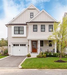 a two story house with white siding and brown doors