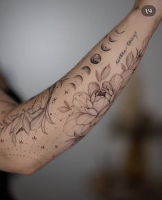 a woman's arm with flowers and planets on it