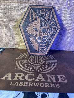 an arcane laser works box sitting on top of a table