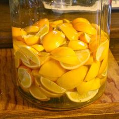 a jar filled with lemons sitting on top of a wooden table