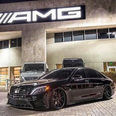 two cars parked in front of a building with the word amg written on it