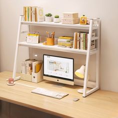 a computer on a desk with books and other office supplies in front of the monitor