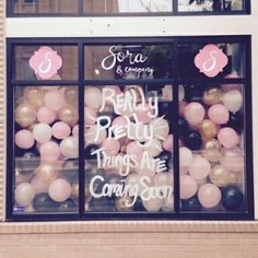 there is a store front with balloons in the window