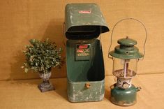 an old fashioned green machine next to a potted plant