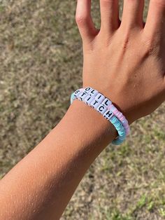 a child's hand wearing a bracelet with the word faith written on it in white and blue