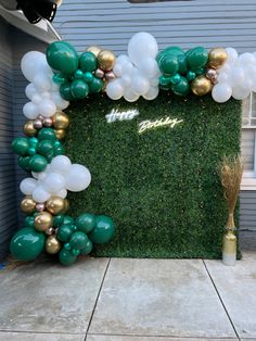 a green and white backdrop with balloons