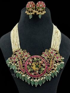 Navratan Kemp Necklace with Pearls captures the essence of South Indian jewelry, inspired by Sabyasachi. This Heavy Bridal Temple Necklace is a statement piece perfect for a Bollywood Wedding, blending tradition with opulence. It makes a magnificent gift, symbolizing cultural heritage and timeless beauty for the bride. *𝐏𝐑𝐎𝐃𝐔𝐂𝐓 𝐃𝐄𝐓𝐀𝐈𝐋* * Material: Brass * Plating: Gold Plated * Stone: Semi Precious Beads. *𝐃𝐈𝐒𝐂𝐋𝐀𝐈𝐌𝐄𝐑* Product color may slightly vary due to photographic lig Luxury Temple Necklace For Navratri Rituals, Luxury White Temple Necklace, Luxury Temple Necklace With Polished Beads For Wedding, Luxury Temple Necklace For Navratri Celebration, Kundan Necklace With Peacock Design For Reception, Reception Kundan Chandbali Necklace With Peacock Design, Kundan Chandbali Necklace With Peacock Design For Reception, Festival Reception Kundan Necklace With Peacock Design, Traditional Kundan Necklace With Peacock Design For Reception