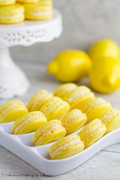 there are many lemons on the tray and one is yellow with white icing