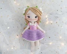 a crocheted doll is posed on a white background with stars and circles around it