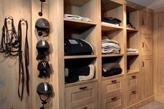 a wooden closet filled with lots of horse riding gear