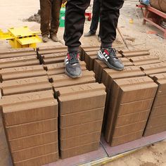 two people standing on top of some brown boxes