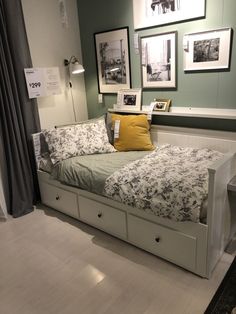 a bed with drawers underneath it and pictures on the wall