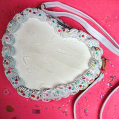 a heart shaped cake sitting on top of a table next to a pair of headphones