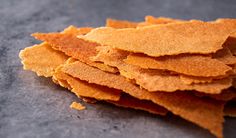 a pile of crispy crackers sitting on top of a gray countertop next to a knife