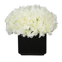 a black vase with white flowers in it