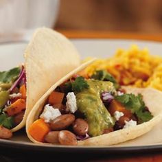 two tortillas with beans and vegetables on a plate