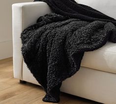 a white couch with a black blanket on it