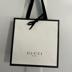 a gucci shopping bag hanging on a door with the word'beauty'printed on it