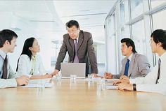 a group of business people sitting around a conference table