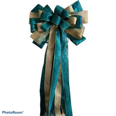 a blue and gold bow with ribbons on it's side, against a white background