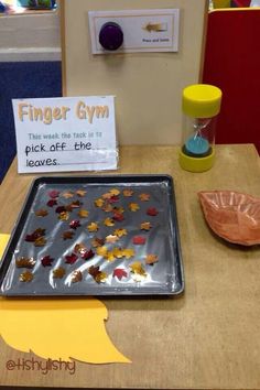 a metal pan with leaves on it next to a sign that says finger gyr