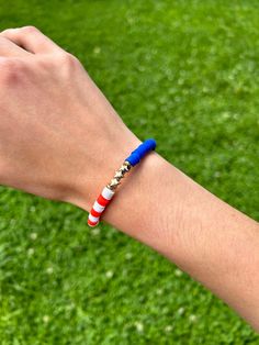 a person's arm with a bracelet that has an american flag bead on it