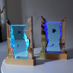 two pieces of wood that have been cut into shapes with blue lights on the sides