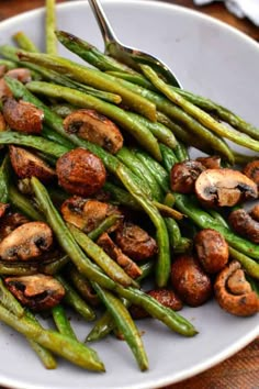 green beans and mushrooms on a white plate with a fork in the middle, ready to be eaten