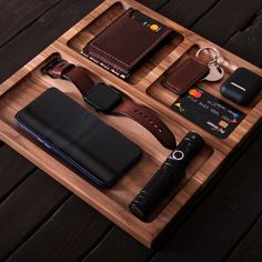 a wooden tray with wallets and other items on it