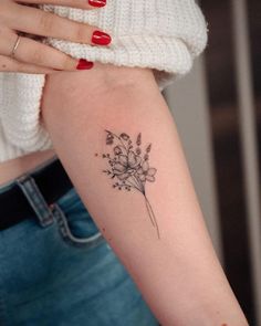 a woman's arm with a flower tattoo on the left side of her arm