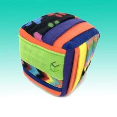 a multicolored square shaped case with multiple colors and designs on the front, sitting against a blue background