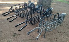 several bikes parked next to each other in the dirt near a tree with no leaves on it