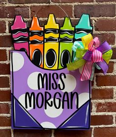 a sign that says miss morgan with crayons in it on a brick wall