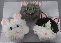 three decorated cupcakes with cats on them