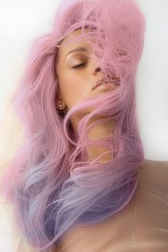 a woman with pink and blue hair laying down