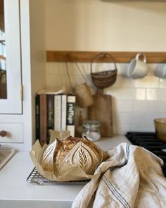 a loaf of bread sitting on top of a kitchen counter next to a book shelf