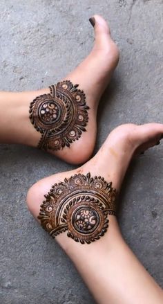 two feet with henna tattoos on them